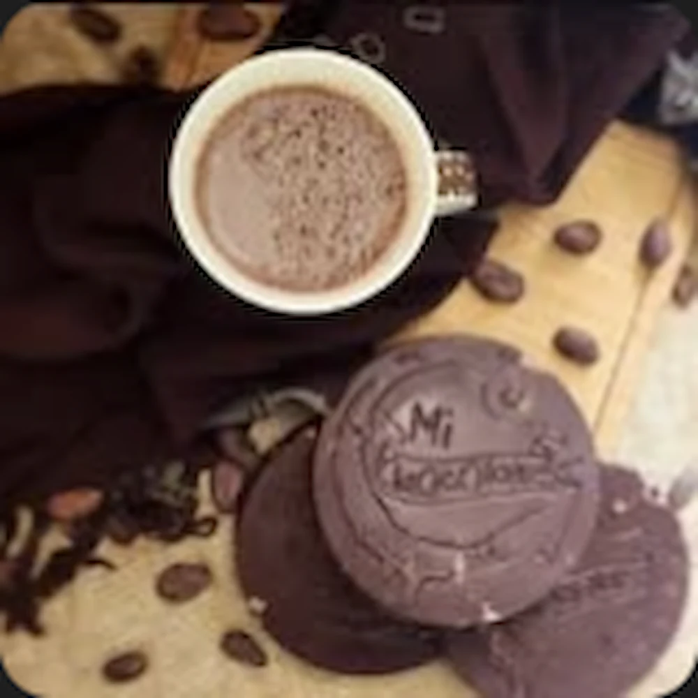Tabletas de chocolate Mi Chocolate junto a una taza de chocolate caliente y granos de cacao